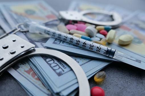 close up of pills syringe and cash on on table picture id1211271471?b=1&k=6&m=1211271471&s=170667a&w=0&h=QERL Ql0Ok77OcBDk188awah4Dacw3B7uZERVypDP1k=