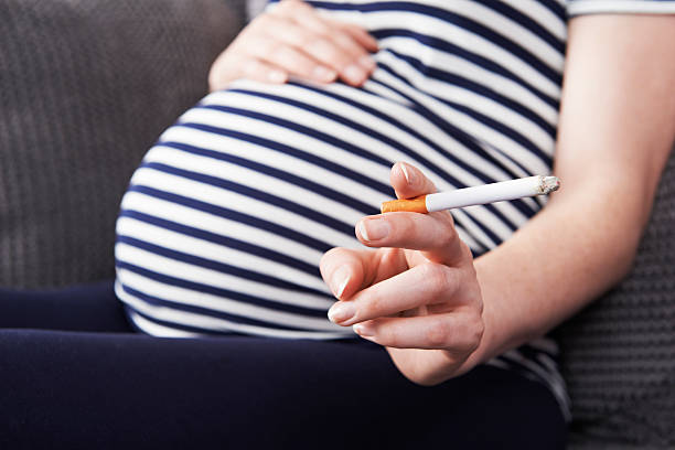 Close Up Of Pregnant Woman Smoking Cigarette stock photo