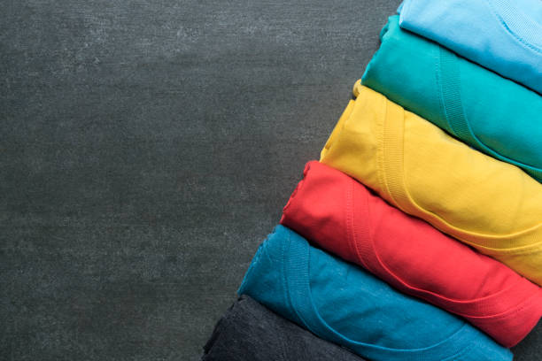 close up of rolled colorful clothes on black background stock photo