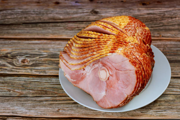 Close up of sliced honey smoked ham on wooden table. Close up of sliced honey smoked ham on wooden table. Copy space. ham stock pictures, royalty-free photos & images