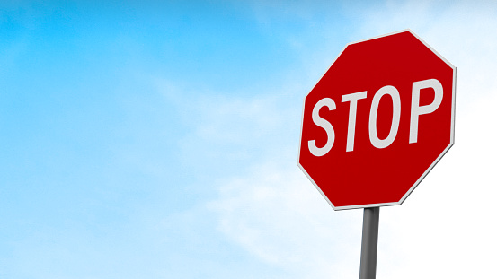 3D Rendering, Close up of stop traffic sign with cloudy blue sky background.
