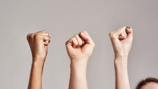 Close up of three raised fists of diverse women. Feminism, equality and women liberation concept. Selective focus. Web Banner