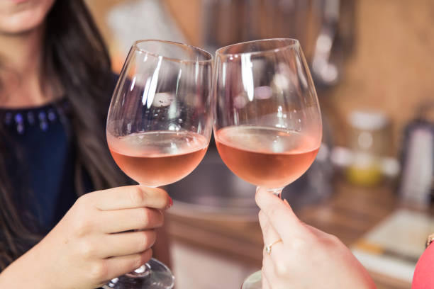 Close up of toasting with wine. Close up of women toasting with rose wine while celebrating success. rose wine stock pictures, royalty-free photos & images