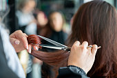 istock Close up of unrecognizable hairdresser cutting a female customerâs hair 1349298950