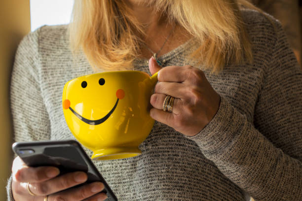 Close Up of Woman Holing Phone and Smile Mug stock photo