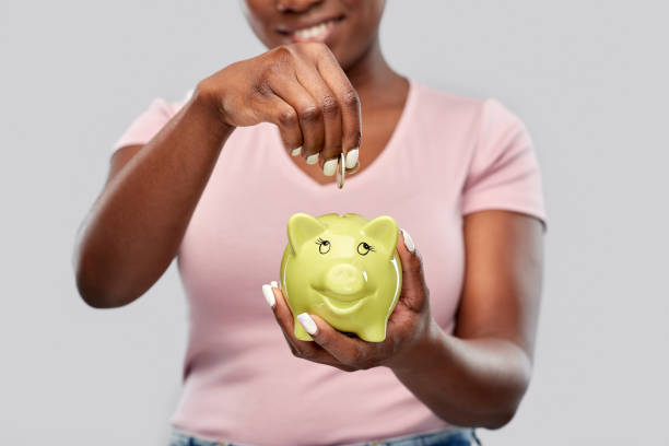 close up of woman with coin and piggy bank stock photo