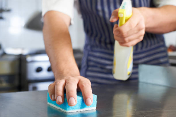 Close Up Of Worker In Restaurant Kitchen Cleaning Down After Service stock photo