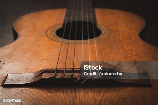 istock Close up on classic guitar bridge focus on foreground 1300197680