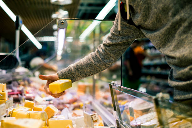 close up person hand buying cheese in  store close up person hand buying cheese in the  store delicatessen stock pictures, royalty-free photos & images