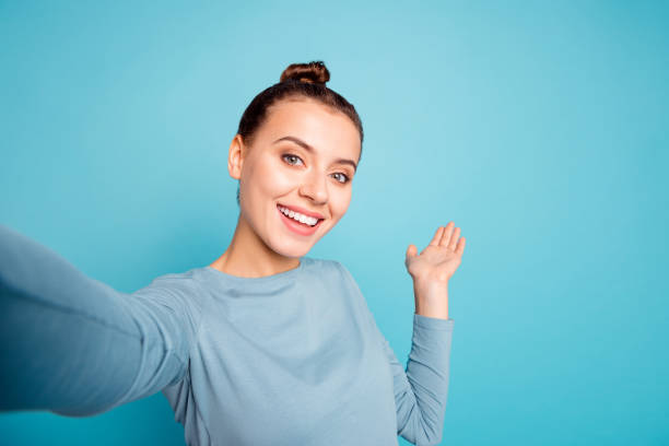 클로즈업 사진 아름 다운 놀라운 그녀는 그녀의 여자는 셀 카 쇼 손 팔 팜 공기를 보여주는 방법도  로 외국인 방송 블로그 착용 캐주얼 스웨터 풀 오버 고립 된 파란색 밝은 배경 - selfie 뉴스 사진 이미지