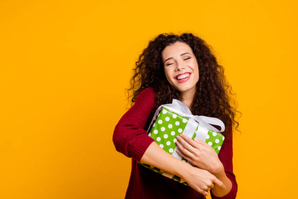close up photo beautiful cheerful amazing her she lady hold large package my precious only mine waited long time wearing red knitted sweater pullover clothes outfit isolated yellow background - woman holding a christmas gift imagens e fotografias de stock