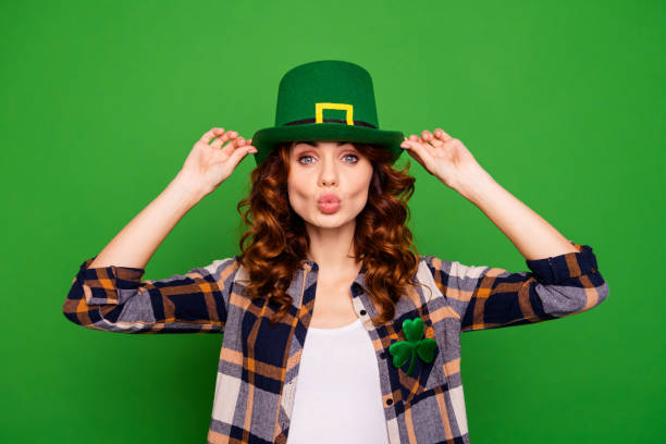 Close up photo of cool attractive she her lady holding hands cap sending kiss to ireland people wearing casual checkered plaid shirt leprechaun headwear isolated on green bright vivid background Close up photo of cool attractive she her lady holding hands cap sending kiss to ireland people wearing casual checkered plaid shirt leprechaun headwear isolated on green bright vivid background irish women stock pictures, royalty-free photos & images