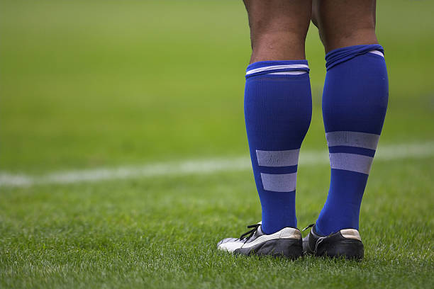 Close up photo of rugby player's blue socks and white shoes stock photo