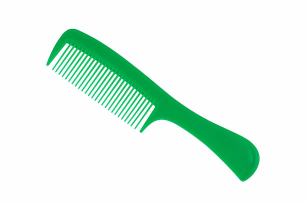 Close up photography of beautiful clean empty green color new plastic comb and equipment of hairdresser isolated on white background. stock photo