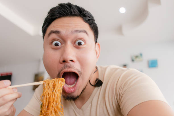 Close up portrait of happy Asian man eat noodle. stock photo
