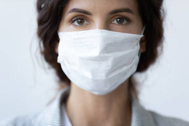 Close up portrait of woman wear face mask Close up portrait of beautiful 30s young millennial woman cover her face wearing facial medical blue mask, anti-coronavirus COVID-19 pandemic infectious disease outbreak protection, healthcare concept nurse face stock pictures, royalty-free photos & images