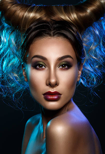 Close up portrait young woman with bright fantasy make up Close up portrait young woman with bright fantasy make up and creative hairstyle. Colorful light. The girl in the image of Capricorn. capricorn stock pictures, royalty-free photos & images