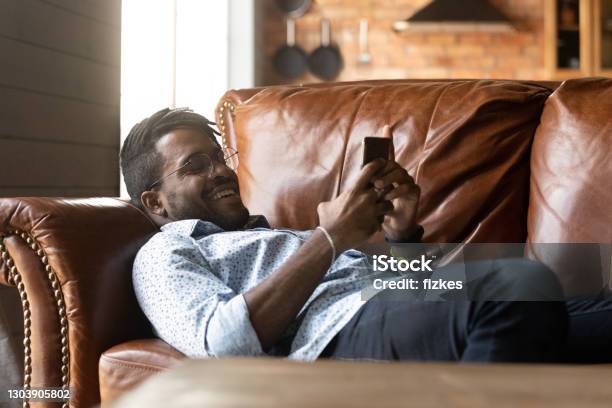 Close up smiling African American man using phone, relaxing