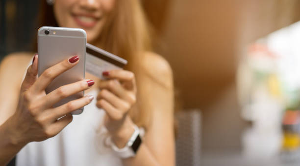 close up teenage girl using smartphone for choose or search or order product from marketplace website and pay by credit card at office , modern lifestyle and shopping concept  credit card purchase stock pictures, royalty-free photos & images
