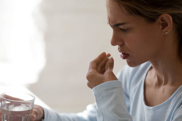 närbild av ohälsosamma kvinna håll glas stilla vatten och piller - alvedon bildbanksfoton och bilder
