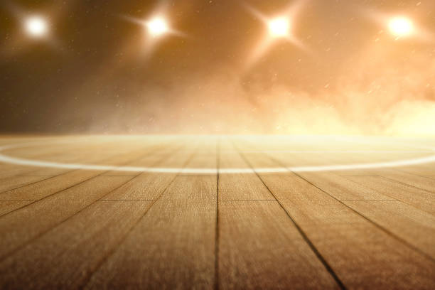 Close up view of a basketball court with wooden floor and spotlights Close up view of a basketball court with wooden floor and spotlights over dark background basketball court stock pictures, royalty-free photos & images