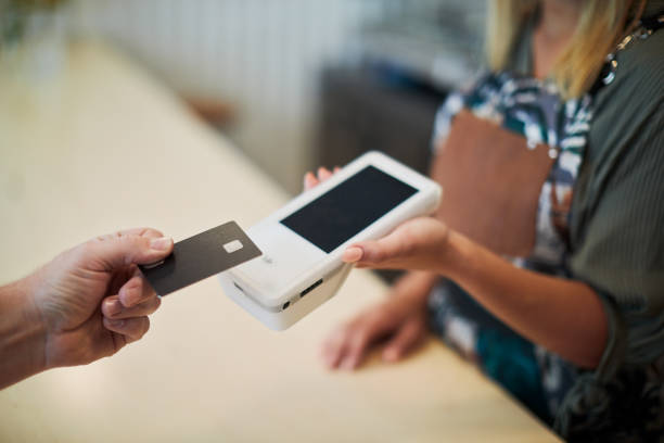 Close up view of a hand holding a card near a card reader. Technology and retail.
Contactless payment with a credit card. credit card reader stock pictures, royalty-free photos & images