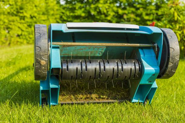 Close up view of electric lawn aerator on green grass isolated. Garden machines concept. stock photo