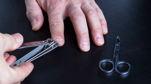 Close up view of male taking care of his own nails. Manicure concept. stock photo