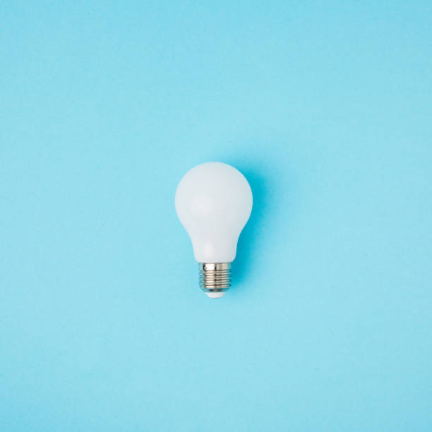 close up view of white light bulb isolated on blue close up view of white light bulb isolated on blue simplicity photos stock pictures, royalty-free photos & images