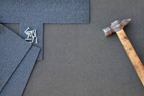 Close up view on asphalt shingles on a roof  with hammer and nails background. stock photo