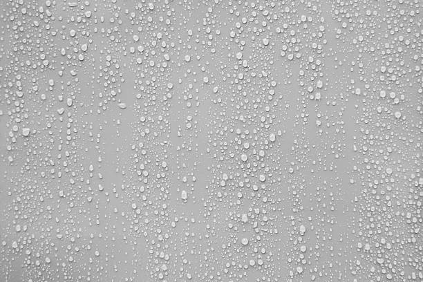 close up water drop on grey background. - condensatie stockfoto's en -beelden