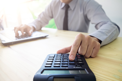 Close Up Young Asian Business Man Using A Calculator To Calculate
