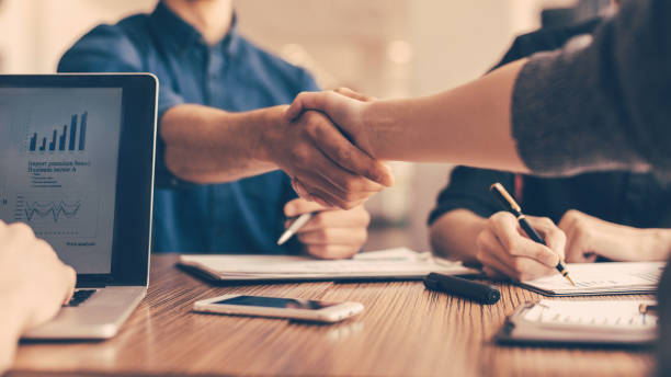 close up. young people greeting each other at the work table close up. young people greeting each other at the work table. concept of cooperation . business handshake stock pictures, royalty-free photos & images