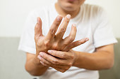istock Close up,asian middle-aged man with shaking of Parkinson's disease,symptom of resting tremor,male patient holding her hand to control hands tremor,neurological disorders,brain problems,health care 1345447427