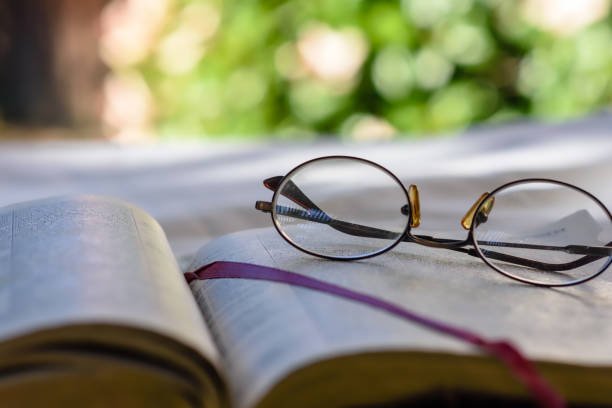 Close view glasses on bible pages stock photo