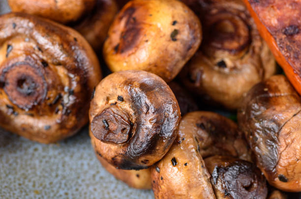 A close view of grilled button mushrooms on a blue plate stock photo