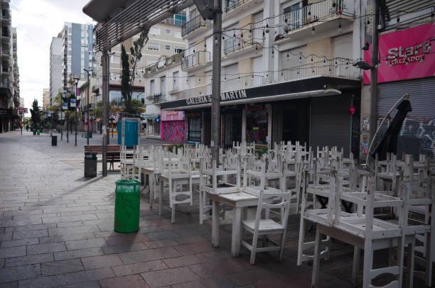 Closed sidewalk cafe during lockdown on Peatonal San Martin street. Chairs placed on top of the tables before the opening of the restaurant. stock photo