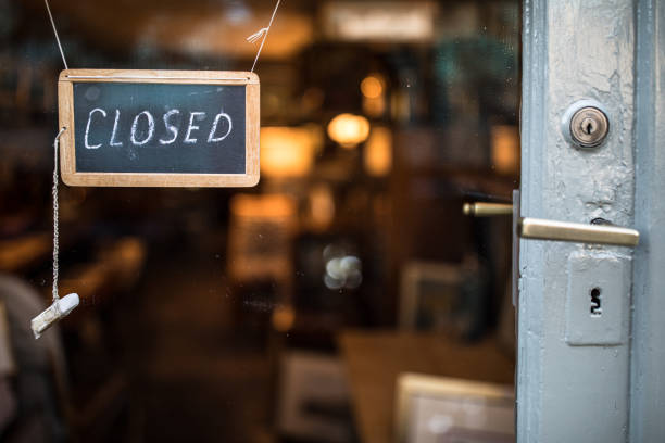 Closed - sign hanging on glass door Closed - sign hanging on glass door of a shop in a city closing stock pictures, royalty-free photos & images