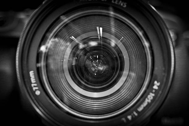A close-up black and white image of a camera lens stock photo