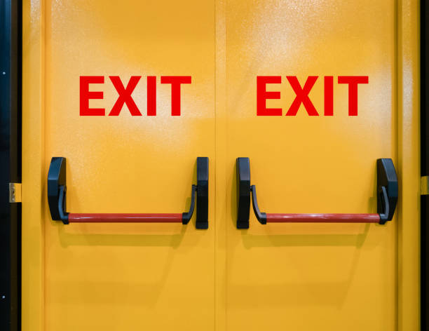 closeup bright vivid yellow double doors for emergency exit - planear obras vermelho imagens e fotografias de stock