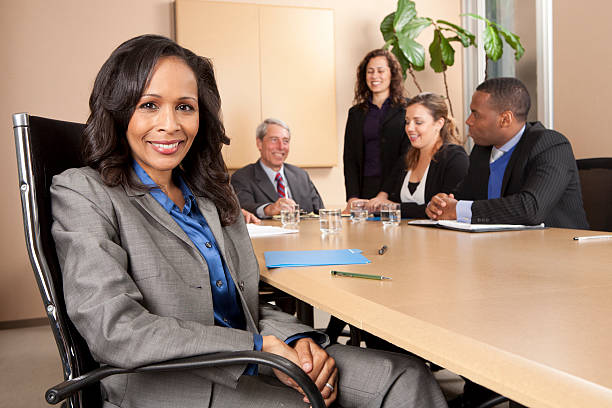 Close-up businesswoman with associates in the background stock photo