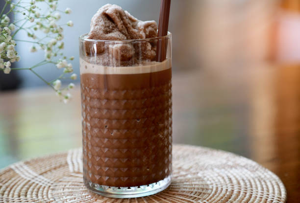 Closeup chocolate smoothie in the glass on wooden table background. Drinks or summer season concept. stock photo
