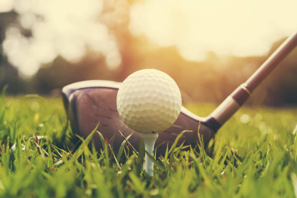 日没と緑の草のクローズアップゴルフクラブとゴルフボール - ゴルフ　服装 ストックフォトと画像