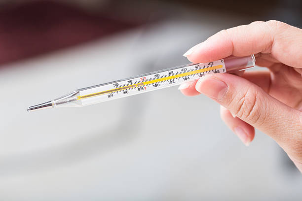 Close-up hand holding on thermometer for checking patient. stock photo