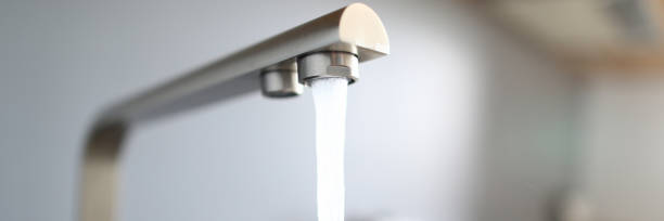 Close-up jet water from silver tap in kitchen Close-up jet water from silver tap in kitchen. Install mixer correctly and avoid leakage. Water filtration systems in an apartment in kitchen. Cleanliness in kitchen and access to water faucet stock pictures, royalty-free photos & images