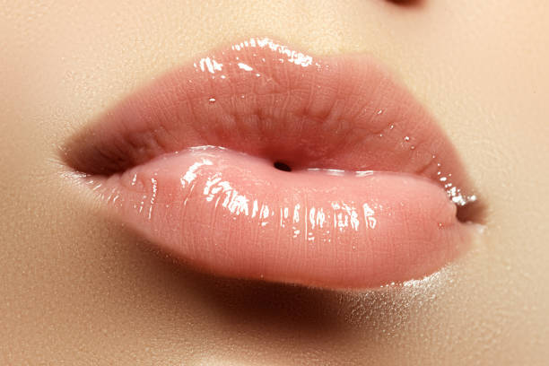 Close-up of a beautiful sexy natural lips giving kiss. Full lips Close-up of a beautiful sexy natural lips giving kiss. Nice full lips with gloss lip makeup. Fashion makeup. Sexy lips. Beauty lips makeup detail shiniest lip gloss stock pictures, royalty-free photos & images