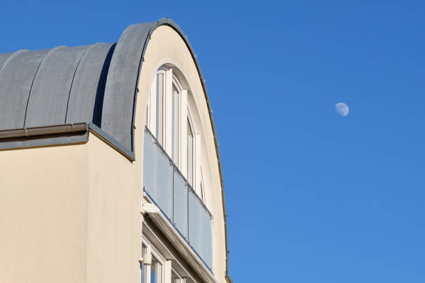 Close-up of a bright apartment building with the mooon in the blue sky stock photo