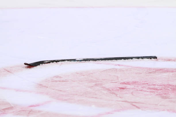 Closeup of a broken ice hockey stick laying on the ice stock photo