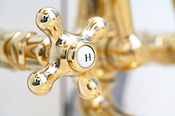 Close-up of a gold faucet for hot water in a bathroom stock photo