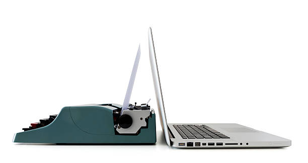 A close-up of a laptop and an old typewriter contemporary laptop facing an old vintage typewriter, present facing past old vs new stock pictures, royalty-free photos & images
